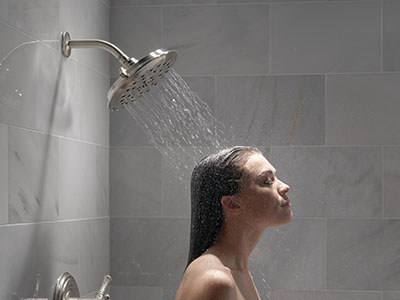 Woman taking a saturating shower using UltraSoak Spray shower head