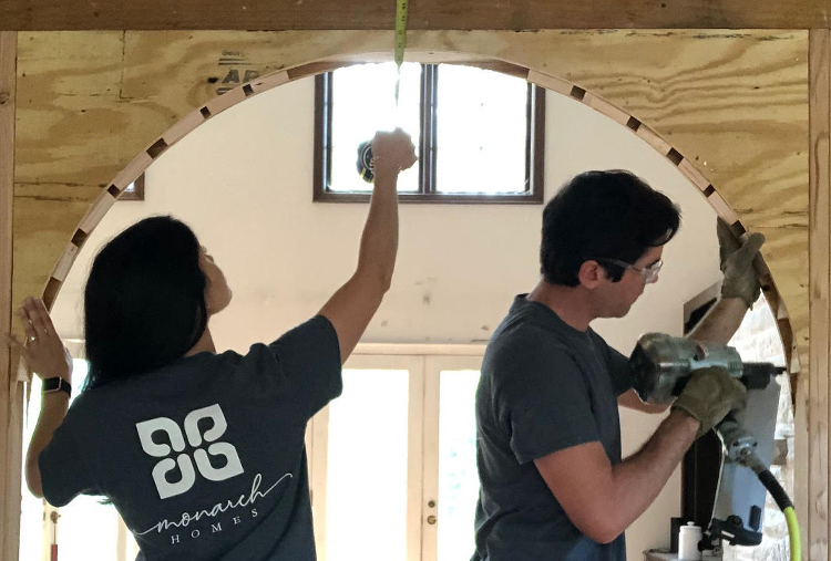 Mike and Hannah, dressed in grey t-shirts, work together on door archway